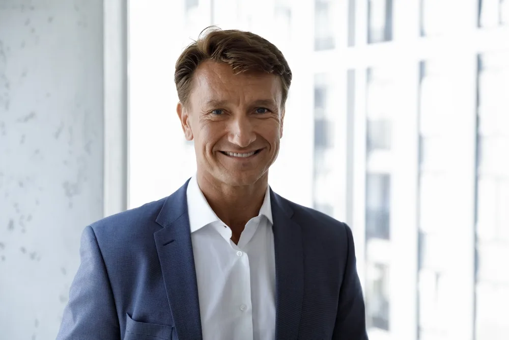 Portrait of a smiling man in a navy blazer and white shirt