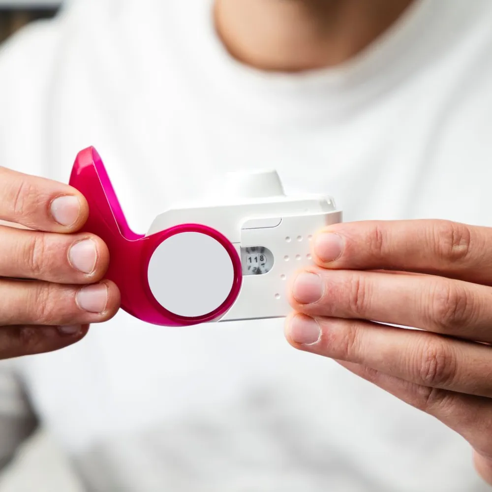 Hands holding a peak flow meter for a breathing test