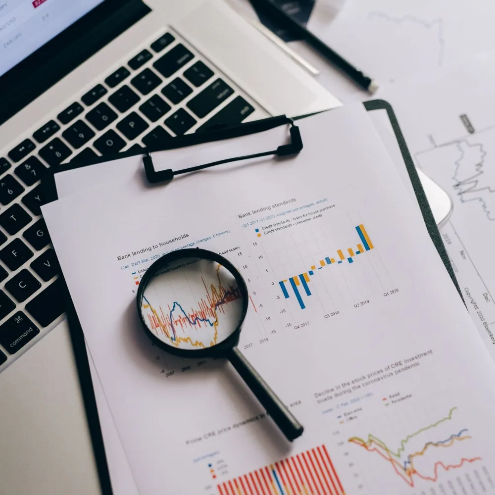 Magnifying glass over printed charts and statistics during a billing review