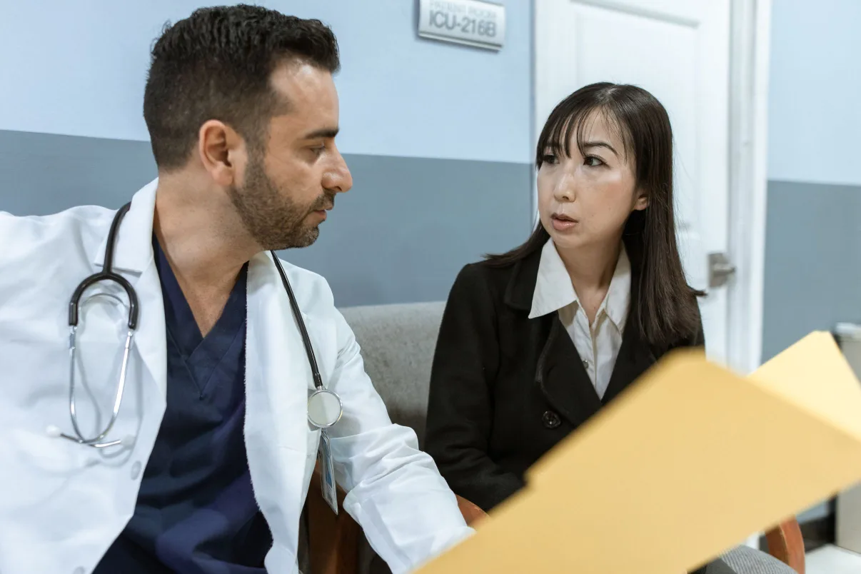 Billing consultant going over findings in a folder with a physician