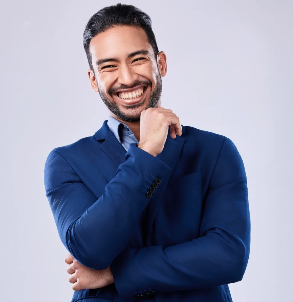 Portrait of a smiling bearded man in a blue blazer with his arms crossed