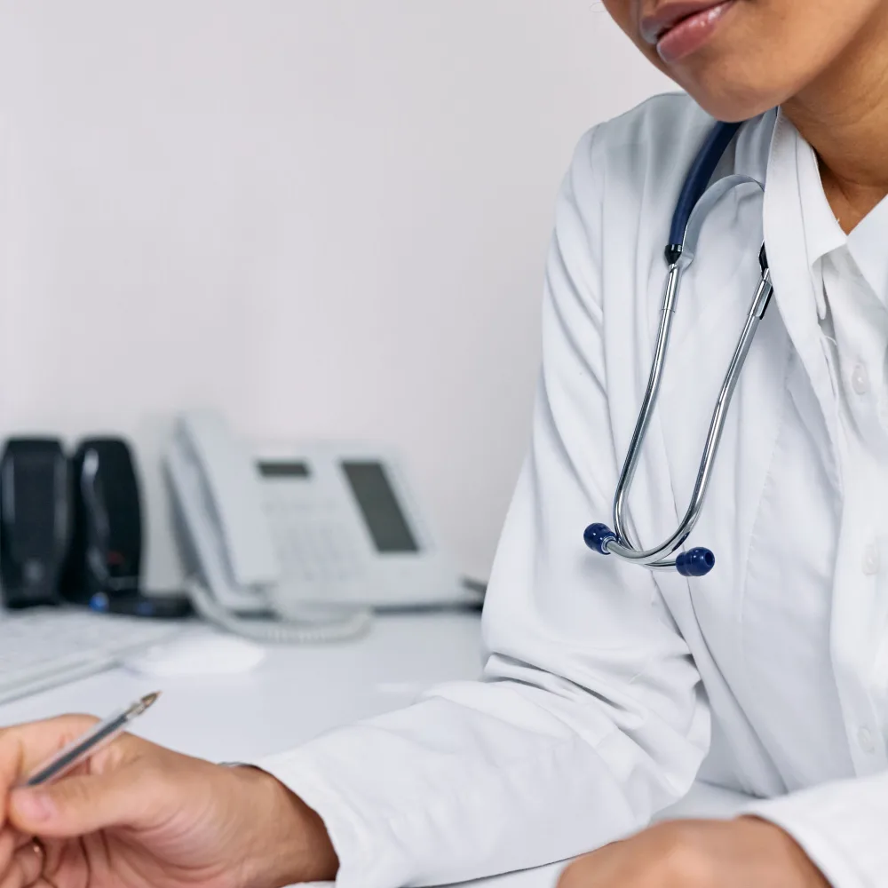 Doctor filling out a patient chart at a desk