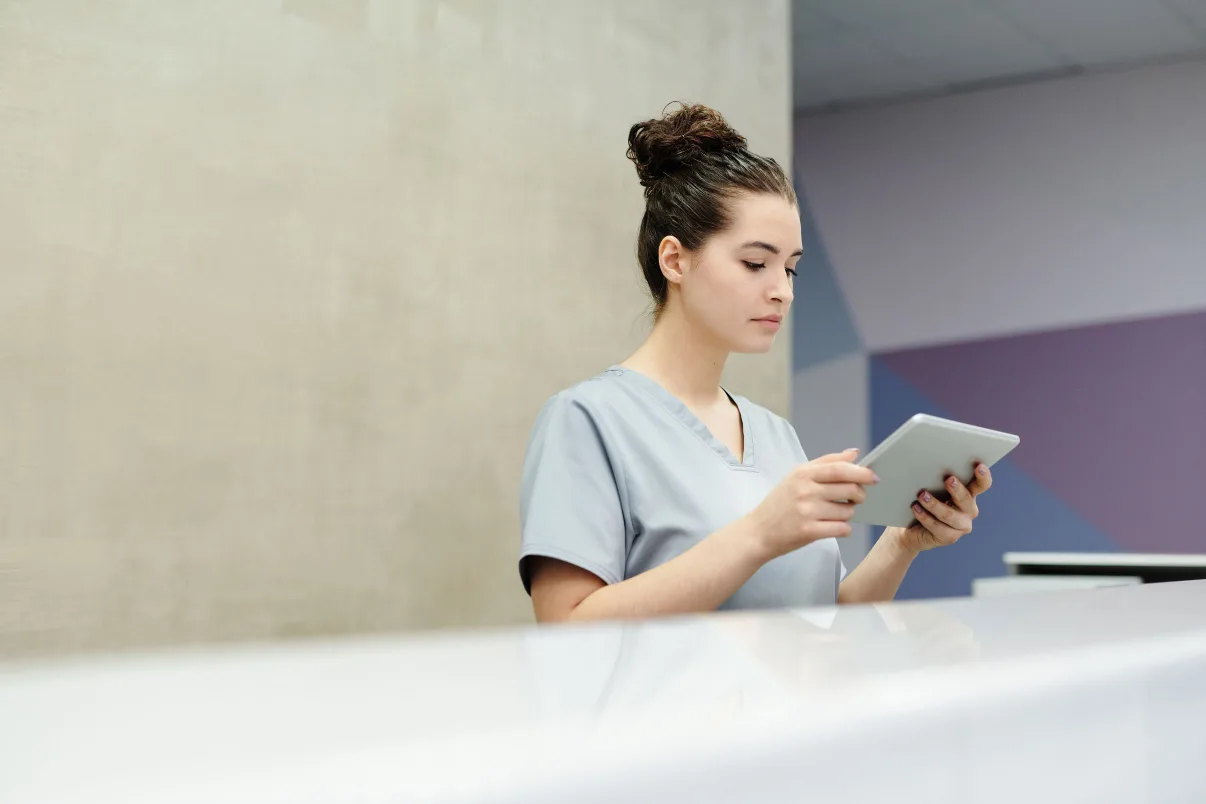 Front desk staff member checking patient insurance details on a tablet