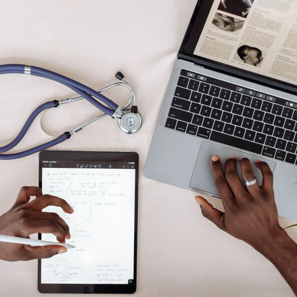 Stethoscope beside a laptop and a tablet used for online credentialing