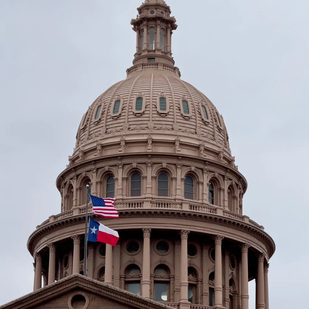 Texas State Capitol dome with the US and Texas flags