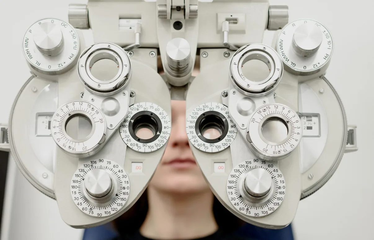 Patient having an eye exam with a phoropter at an ophthalmology clinic